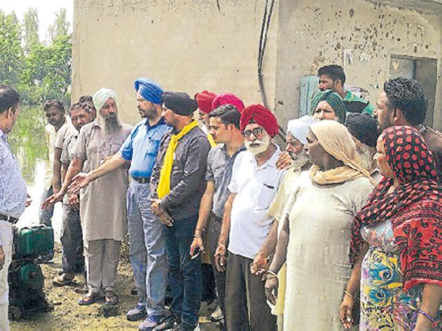 Aam Aadmi Party workers starting a diesel motor to drain water out of a puddle near a Dalit colony of Nabha’s Thuhi village. (HT Photo) Aam Aadmi Party workers starting a diesel motor to drain water out of a puddle near a Dalit colony of Nabha’s Thuhi village. (HT Photo)