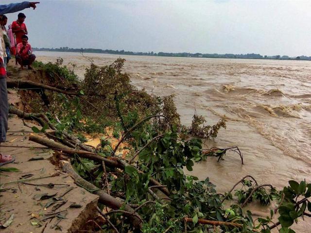 Villagers watch land erosion along a river at a flood-hit village in Kishanganj district of Bihar. (PTI file photo) Villagers watch land erosion along a river at a flood-hit village in Kishanganj district of Bihar. (PTI file photo)