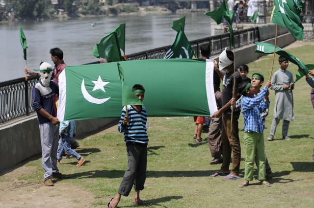Kashmiri protesters hold a flag of Pakistan during celebrations marking Pakistani Independence Day in Srinagar on Sunday (Waseem Andrabi / HT Photo)