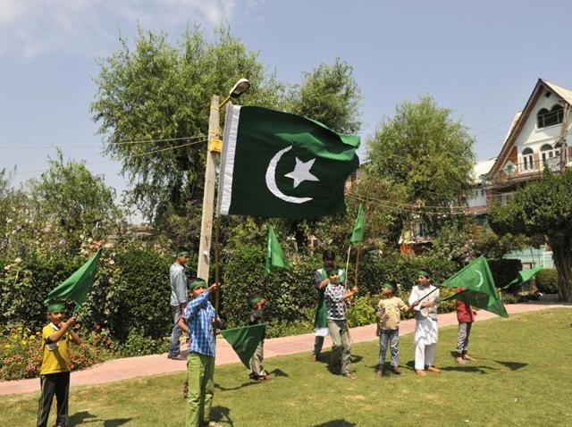 A Kashmiri boy holds the Pakistan flag during celebrations to mark the country’s 70th Independence Day in Srinagar.(Waseem Andrabi/ HT Photo)