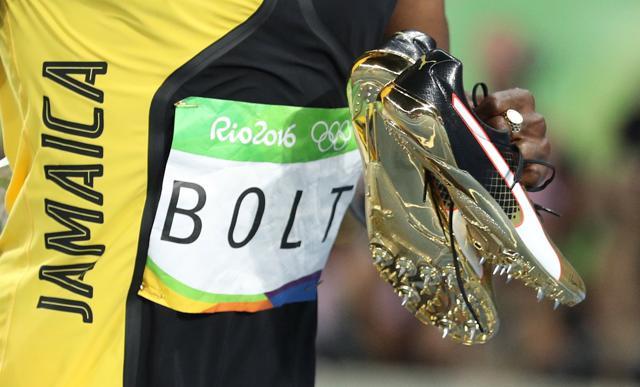 Usain Bolt with his shoes after winning the gold medal. (Reuters)