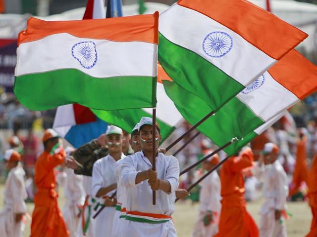 Students wave national flag as they perform during India's Independence Day celebrations, in Jammu. (AP/Channi Anand) 