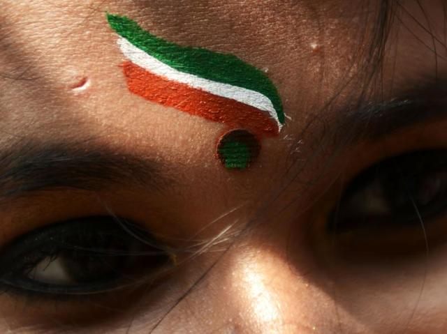 A schoolgirl wears the Indian tricolor as she prepares to participate in a cultural programme for Independence Day celebrations at a school in Kolkata. (AFP/Dibyangshu SARKAR) 