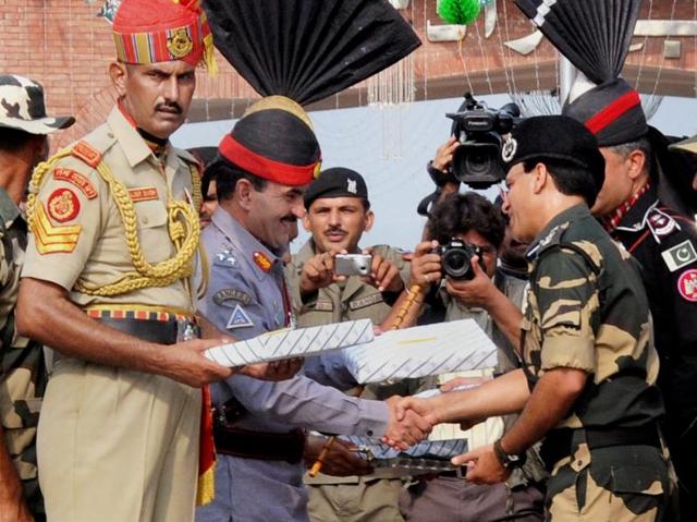 Pakistani Rangers sector commander Shaukat Ali presents sweets to Border Security Force (BSF) Commandant Sudeep on the occasion of Pakistan's Independence Day at the Attari-Wagah border on Sunday. (PTI) Pakistani Rangers sector commander Shaukat Ali presents sweets to Border Security Force (BSF) Commandant Sudeep on the occasion of Pakistan's Independence Day at the Attari-Wagah border on Sunday. (PTI)