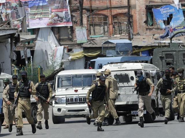 Police run from the building where an encounter was underway in Srinagar. (Waseem Andrabi/ HT Photo) Police run from the building where an encounter was underway in Srinagar. (Waseem Andrabi/ HT Photo)
