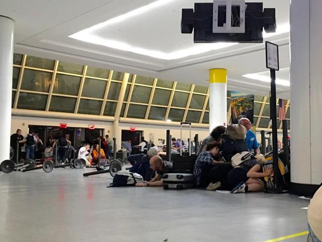 Passengers get down at the immigration control while police looking for an active shooter at JFK International airport in New York on August 14, 2016. (AFP)