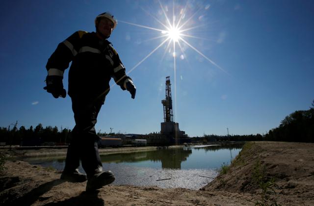 A worker walks past a drilling rig at a well pad of the Rosneft-owned Prirazlomnoye oil field outside the West Siberian city of Nefteyugansk, Russia. (REUTERS) A worker walks past a drilling rig at a well pad of the Rosneft-owned Prirazlomnoye oil field outside the West Siberian city of Nefteyugansk, Russia. (REUTERS)