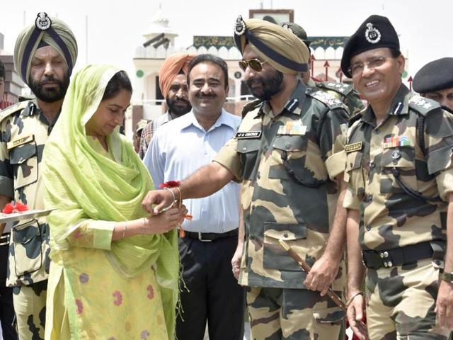 Union food processing minister Harsimrat Kaur Badal tying Rakhi on the wrist of JS Oberoi, DIG Border Security Force (BSF) at Attari-Wagha Border in Amritsar on Wednesday. (Gurpreet Singh/HT Photo)