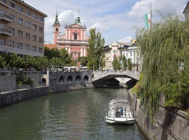 Slovenia has become one of Europe’s hottest nature destinations after breaking away from Yugoslavia in 1991. Tourists and residents walk across Tromostovje bridges in downtown Ljubljana, Slovenia on August 12, 2016.  (AP) 