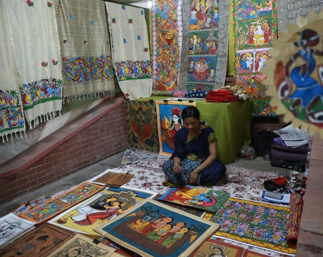 The artist at the West Bengal stall paints stories on canvas (called Patachitra) and sings along to describe various scenes from the paintings. (Amal KS/HT Photo )