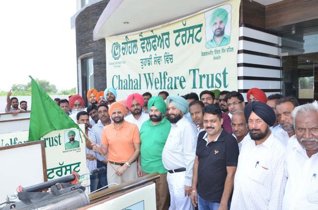 Bikramjit Inder Singh Chahal (orange shirt) with his father Bharat Inder Singh Chahal (green turban) launching the vehicle mounted with anti-mosquito spray. (HT Photo)