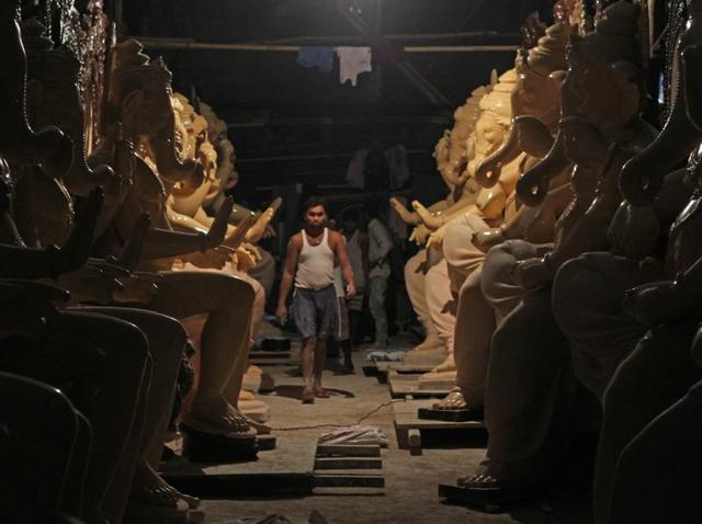 Ganeshotsav gallery: An artist at an idol-making workshop lined with Ganesha idols in Mumbai on Tuesday. (SAtyabrata tripathi) 