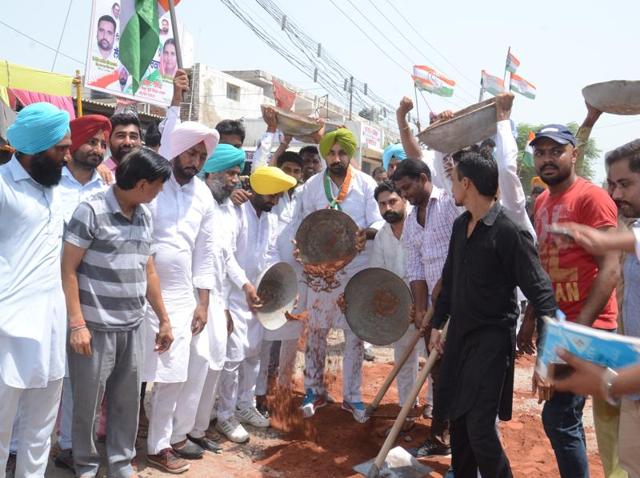 Youth Congress leader advocate Gurpreet Singh (centre) repairing broken roads in Mansa.(HT Photo)