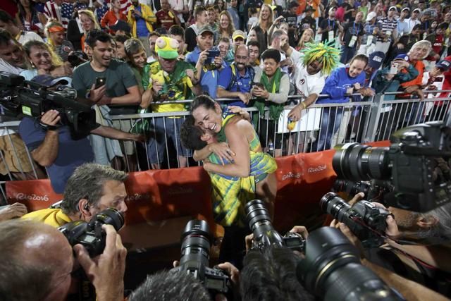 Agatha Bednarczuk embraces the team coach after the win. Brazil’s men’s team of Alison and Bruno also advanced to the gold medal game and will face Italy in the final. (REUTERS)