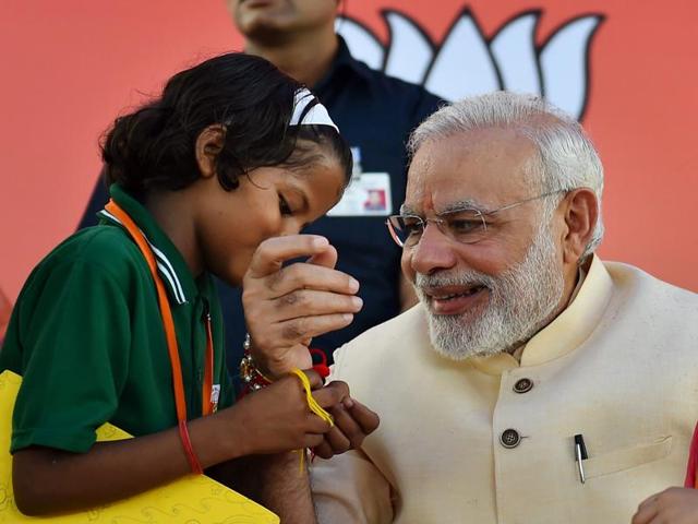 A school girl ties Rakhi to Prime Minister Narendra Modi on the occasion of Rakha Bandhan. (PTI) A school girl ties Rakhi to Prime Minister Narendra Modi on the occasion of Rakha Bandhan. (PTI)