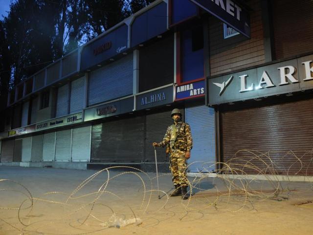 A soldier stands guard during a curfew in Srinagar on Tuesday.(Waseem Andrabi/ HT Photo)
