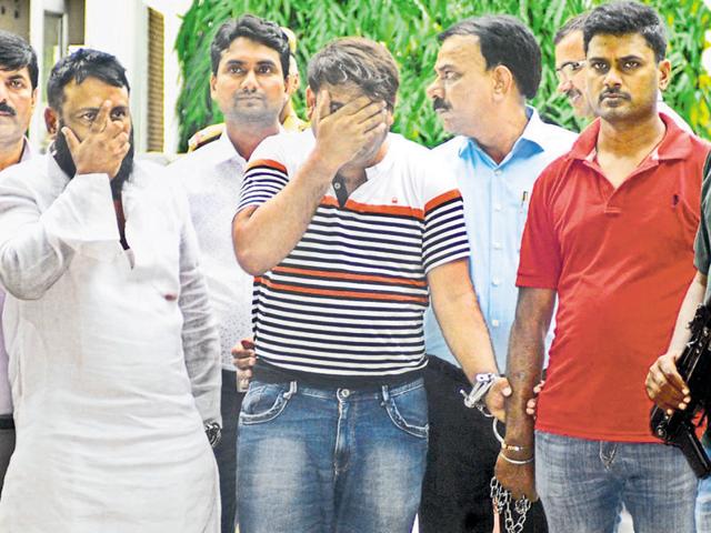 New Delhi: Rehan and Qurban Ansari (covering their faces) were arrested after a brief gunfight near the Indraprastha Park in east Delhi. (HT Photo) New Delhi: Rehan and Qurban Ansari (covering their faces) were arrested after a brief gunfight near the Indraprastha Park in east Delhi. (HT Photo)