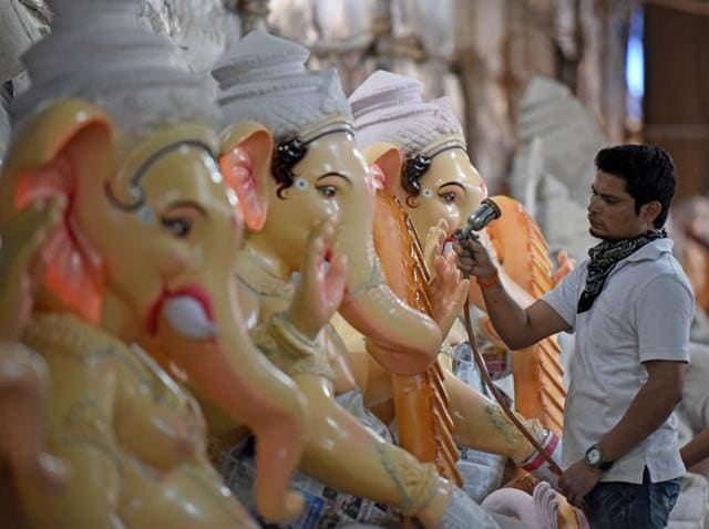 Hand of God: An artist sprays paint on a Ganesha idol. (Pratik Chorge) 