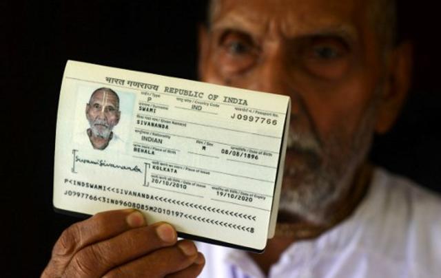 Swami Sivananda holds up his passport in the house of one of his followers in Kolkata. (AFP)