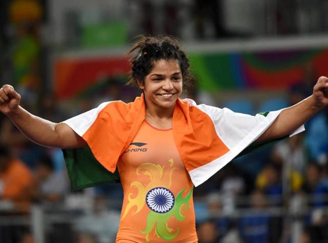 A triumphant Sakshi Malik drapes the Indian flag on her shoulders after winning bronze in the women’s wrestling freestyle 58kg event at the Rio Olympics.(PTI)