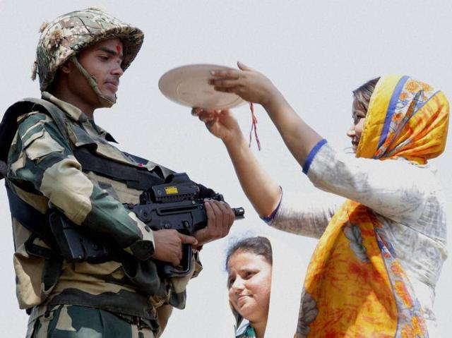 On the occasion of Raksha Bandhan, a girl ties Rakhi on a BSF jawan’s wrist near International Border in Jammu. (PTI) On the occasion of Raksha Bandhan, a girl ties Rakhi on a BSF jawan’s wrist near International Border in Jammu. (PTI)