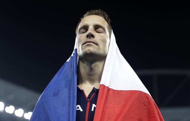 France's Renaud Lavillenie is covered in a French flag as he leaves the stadium after taking the silver medal. (AP) France's Renaud Lavillenie is covered in a French flag as he leaves the stadium after taking the silver medal. (AP)