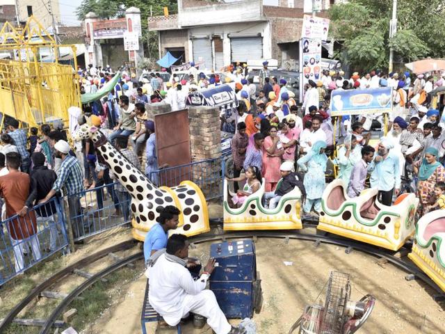 Kids enjoy wings amid a crowd at the Rakhar Punia fair at Baba Bakala in Amritsar on Thursday. (Gurpreet Singh/HT Photo)