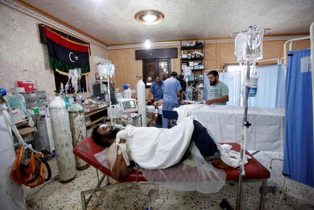 A wounded fighter from Libyan forces, injured during a battle with Islamic State fighters, receives treatment at a field hospital in Sirte. (REUTERS)