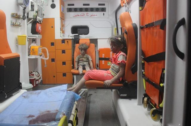 Five-year-old Omran Daqneesh sits with his sister inside an ambulance after they were rescued. (Reuters Photo)