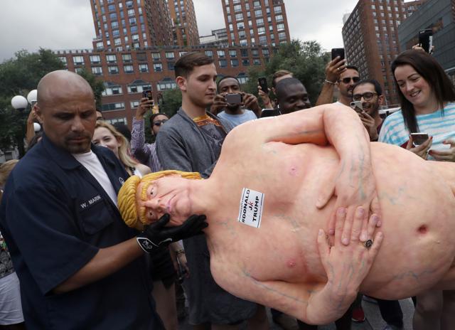 An employee of the New York City Department of Parks &amp; Recreation removes a statue of Donald Trump. (AP Photo)