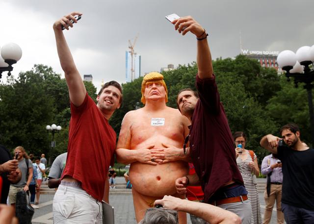 People pose for selfies with a naked statue of US Republican presidential nominee Donald Trump. (REUTERS)