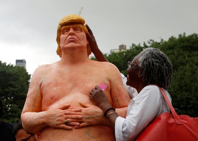 A woman touches a statue Donald Trump that was left in Union Square Park in New York City. (REUTERS)