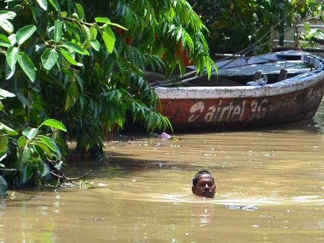 A local wades through neck-deep water in Nagwa area of Varanasi on Saturday.(Adarsh Gupta/HT Photo)