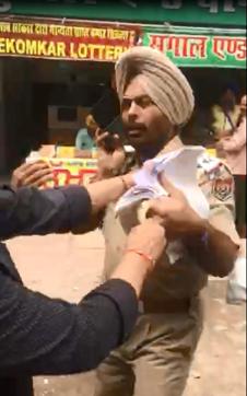 The cop, Varinder Paul, being roughed up by a group of men in Ludhiana on Saturday. (Video grab)