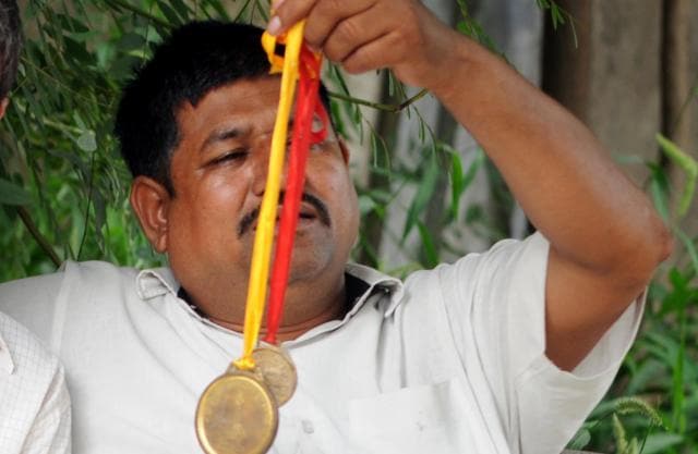 Pooja’s father showing her medals. (Bharat Bhushan/HT Photo) Pooja’s father showing her medals. (Bharat Bhushan/HT Photo)