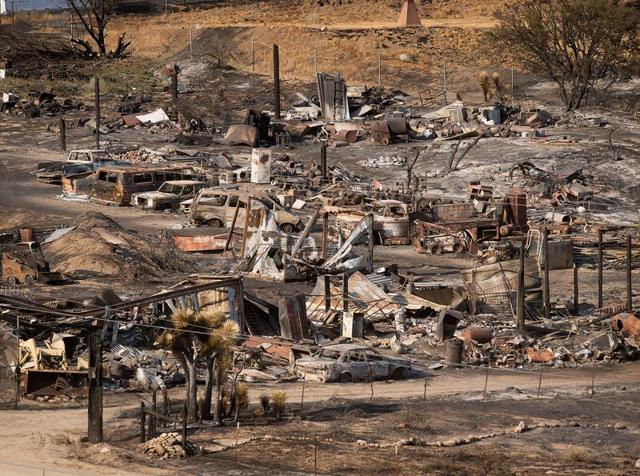 Firefighter Tyler Jaquess of the Del Rosa Hot Shots monitors the Blue Cut fire as it burns in Upper Lytle Creek near Wrightwood, California. (AP)