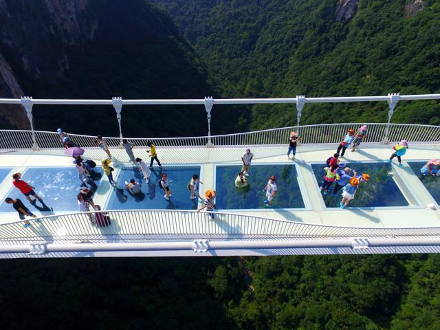 Visitors flocked to the glass-floor suspension bridge in Zhangjiajie in southern China's Hunan Province on August 20, 2016. The bridge, which opened to the public on a trial basis, spans 1,410 feet and rises about 984 feet above a valley in a scenic zone, making it the world's highest and longest glass-bottomed bridge according to Chinese state media. (AP) Visitors flocked to the glass-floor suspension bridge in Zhangjiajie in southern China's Hunan Province on August 20, 2016. The bridge, which opened to the public on a trial basis, spans 1,410 feet and rises about 984 feet above a valley in a scenic zone, making it the world's highest and longest glass-bottomed bridge according to Chinese state media. (AP)