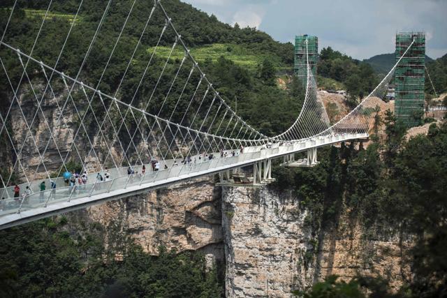 The world's highest and longest glass-bottomed bridge is suspended between two mountains in Zhangjiajie in China's Hunan Province. (AFP ) The world's highest and longest glass-bottomed bridge is suspended between two mountains in Zhangjiajie in China's Hunan Province. (AFP )