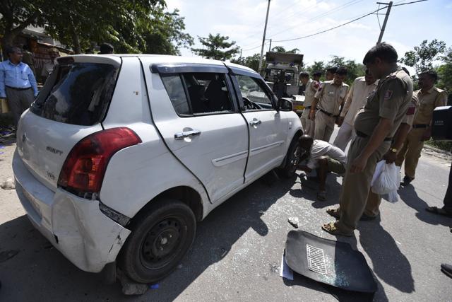 Delhi police officers investigate the car used by the criminals involved in a shootout in Rohini. (Arun Sharma/HT Photo) Delhi police officers investigate the car used by the criminals involved in a shootout in Rohini. (Arun Sharma/HT Photo)