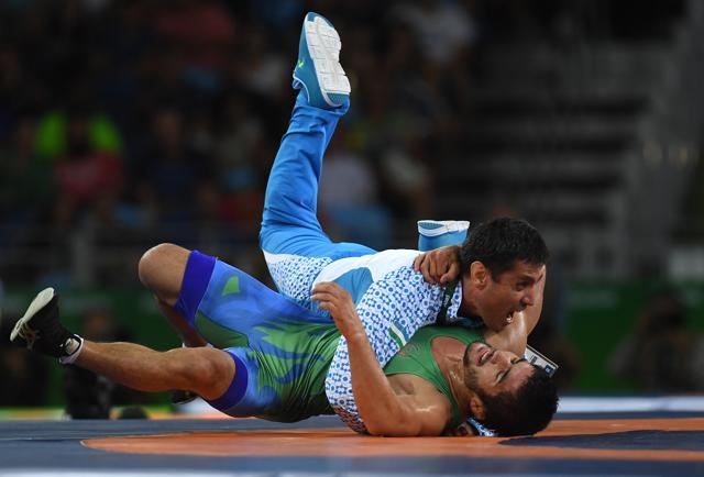 Ikhtiyor Navruzov (blue) of Uzbekistan and coach celebrate after winning the bronze in the Men's Freestyle 65kg Bronze match against Mandakhnaran Ganzorig (red) of Mongolia. (Getty Images) Ikhtiyor Navruzov (blue) of Uzbekistan and coach celebrate after winning the bronze in the Men's Freestyle 65kg Bronze match against Mandakhnaran Ganzorig (red) of Mongolia. (Getty Images)