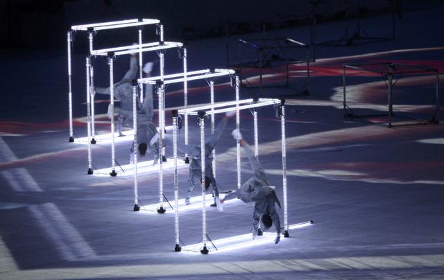 Performers execute a routine with lit trapezoidal props. (REUTERS)