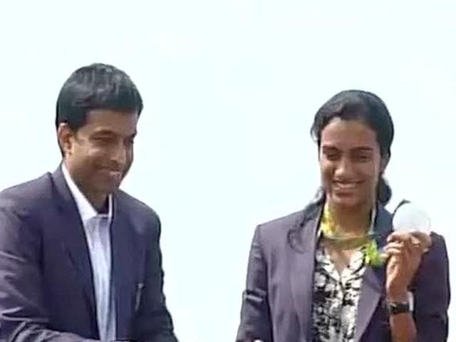 PV Sindhu and coach Pullela Gopichand greet Hyderabad’s citizens from an open-top bus.(Photo: ANI)