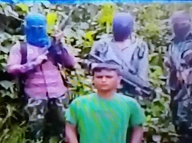 TV grab of the video released by ULFA-I shows Kuldeep Moran surrounded by five masked gun-totting militants. TV grab of the video released by ULFA-I shows Kuldeep Moran surrounded by five masked gun-totting militants.