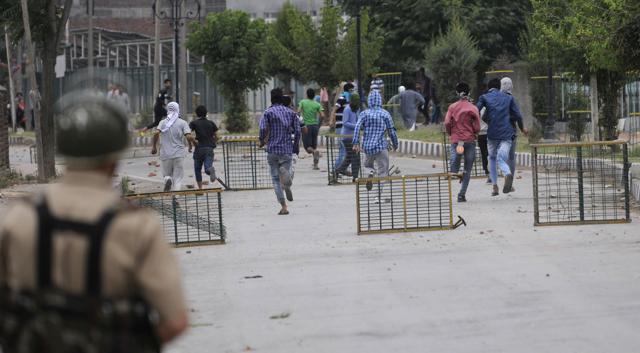 Police personnel chase Kashmiri youth who defied curfew to protest against the death of teenager Irfan Ahmad in security forces action, in downtown area of Srinagar on Monday. (Waseem Andrabi/ HT Photo) Police personnel chase Kashmiri youth who defied curfew to protest against the death of teenager Irfan Ahmad in security forces action, in downtown area of Srinagar on Monday. (Waseem Andrabi/ HT Photo)