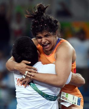 India's Sakshi Malik celebrates with her coach Kuldeep Singh after winning bronze against Kyrgyzstan's Aisuluu Tynybekova in the women's wrestling freestyle 58-kg competition on August 17. (Atul Yadav/PTI  photo) 