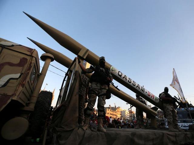 Palestinian members of al-Qassam Brigades, the armed wing of the Hamas movement, display home-made rockets during an anti-Israel military parade, in Rafah in the southern Gaza Strip.(REUTERS)