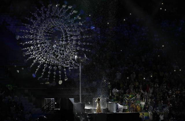 Marlene de Castro performs under the cauldron with the Olympic flame extinguished. (AP)