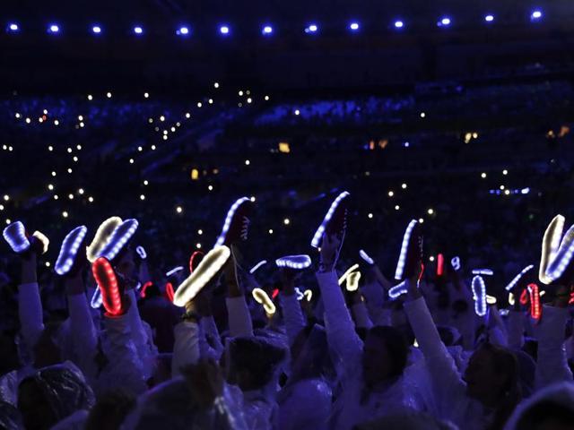 Participants from various countries hold up lit shoes. (AP)