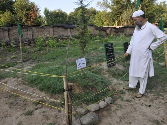 Muzaffar Wani, the father of slain Hizbul Mujahideen commander Burhan Wani, near the grave of his son in in south Kashmir’s Tral.(Waseem Andrabi/ HT Photo) Muzaffar Wani, the father of slain Hizbul Mujahideen commander Burhan Wani, near the grave of his son in in south Kashmir’s Tral.(Waseem Andrabi/ HT Photo)