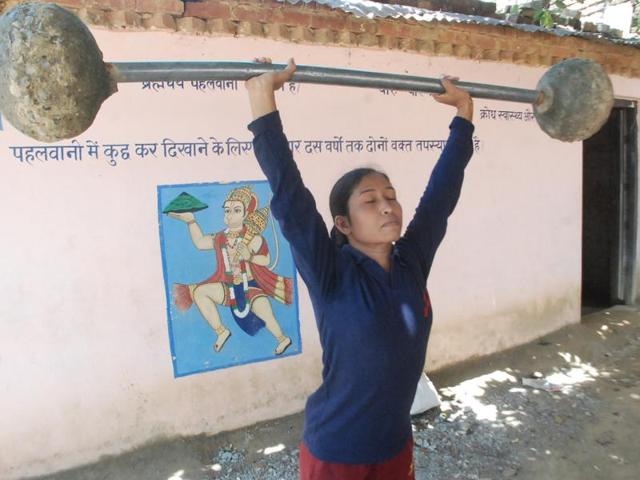 A girl lifts weight made out of a makeshift equipment at the training school in Nibi.(Rajesh Kumar/HT Photo) A girl lifts weight made out of a makeshift equipment at the training school in Nibi.(Rajesh Kumar/HT Photo)